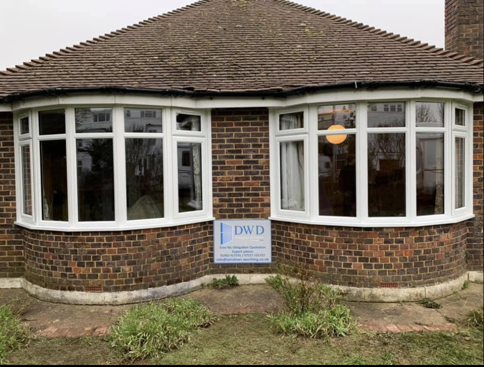 Two new white uPVC bay windows fitted to a brick bungalow