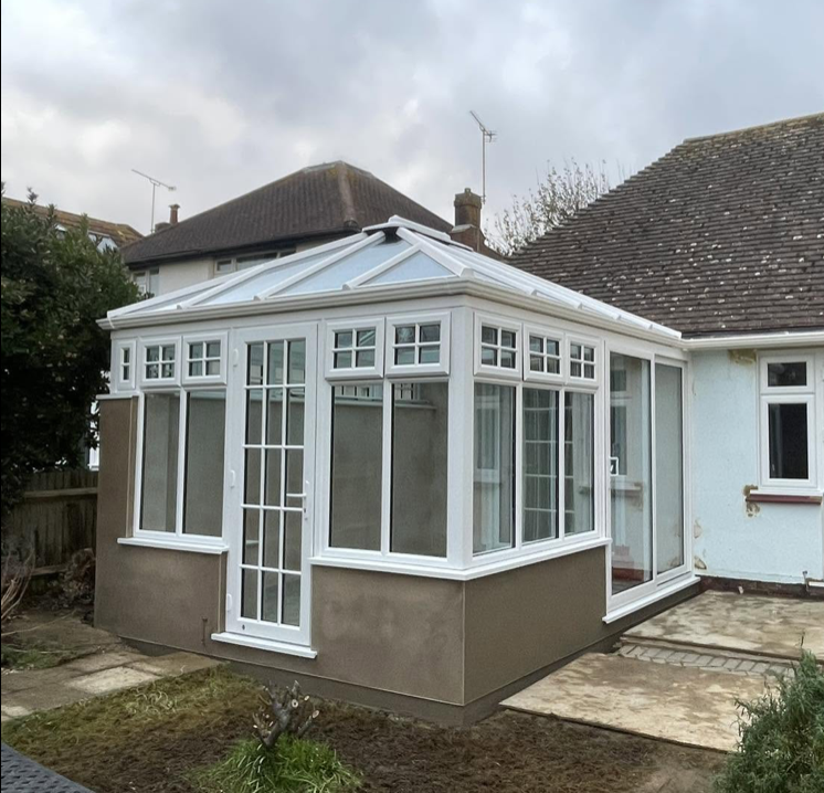 White Georgian bar conservatory with a rendered base on a bungalow