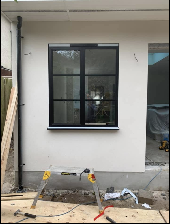 Black aluminium window with Georgian bars fitted to a newly rendered extension