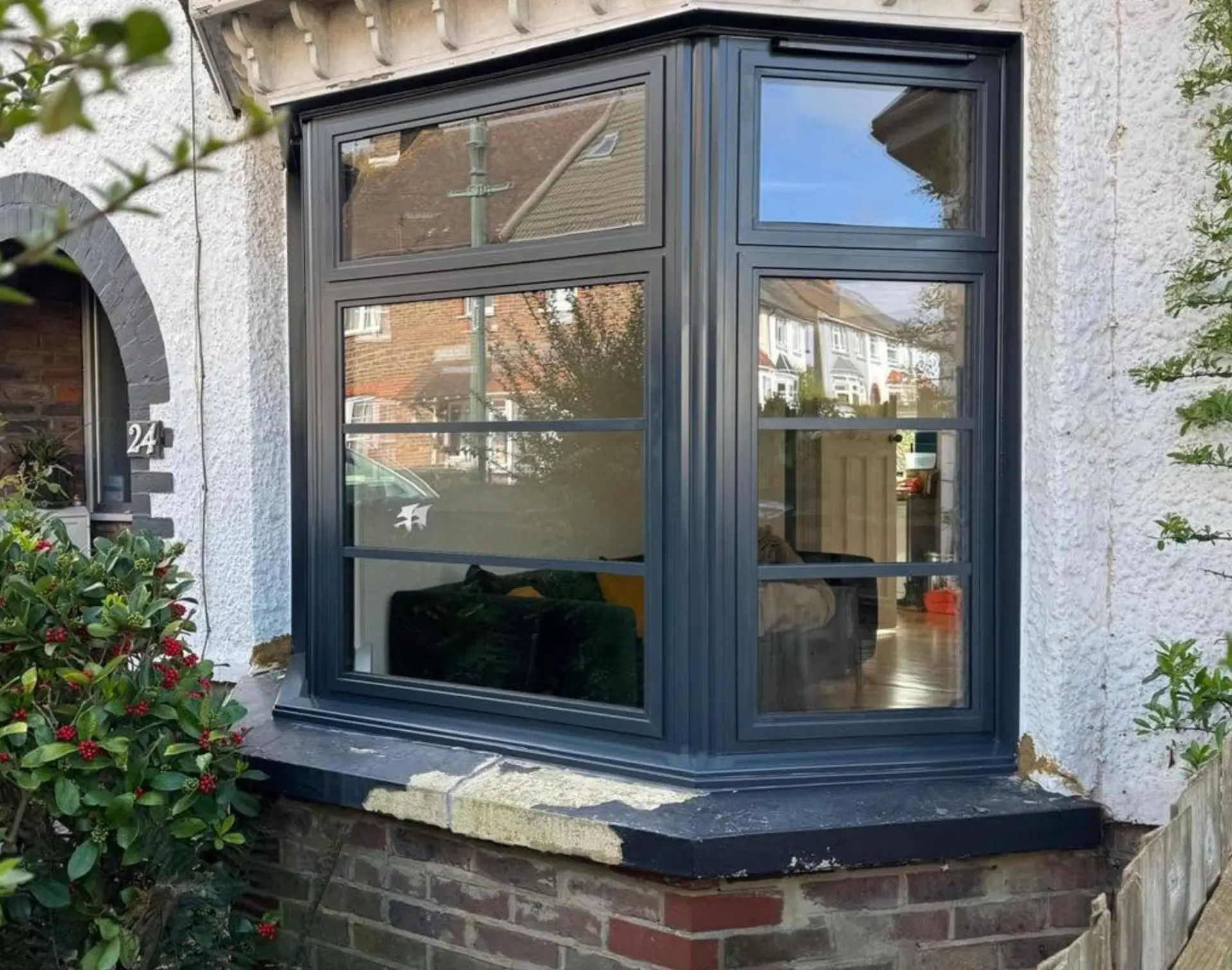 Anthracite grey aluminium bay window with Georgian bars on a rendered house