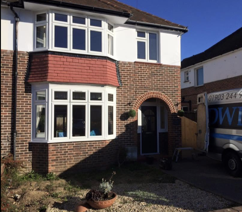 White uPVC bay windows fitted to a red brick Worthing semi