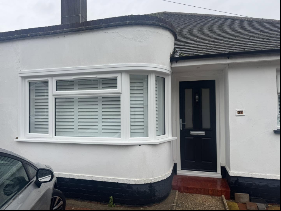 New white uPVC bay window fitted to a rendered bungalow