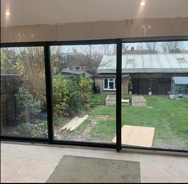 Large black framed sliding patio doors seen from inside a new room