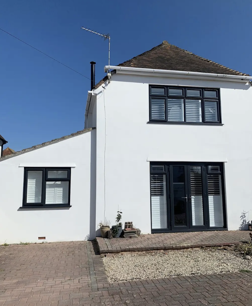Anthracite grey French doors and windows on a white rendered house