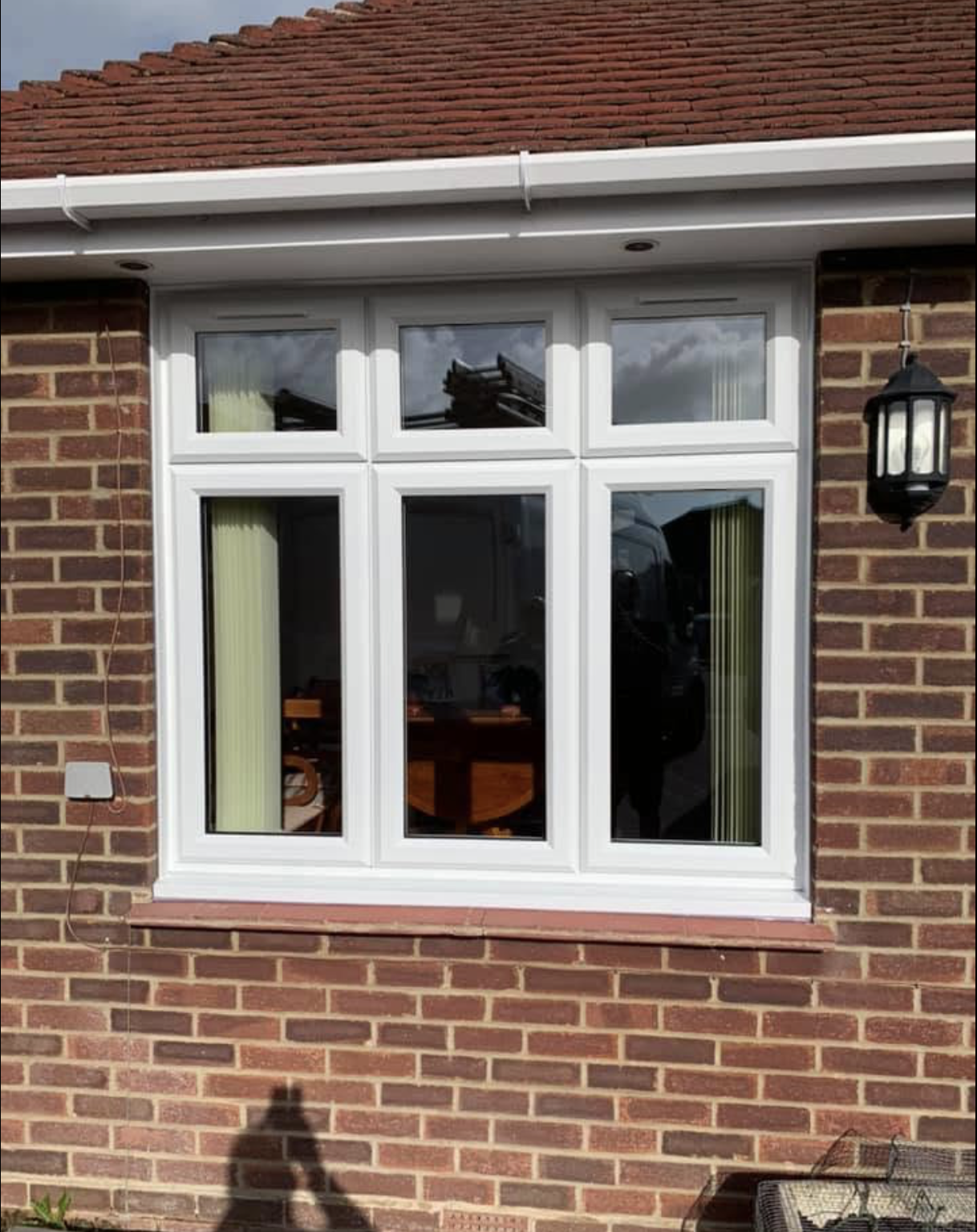New white uPVC casement window fitted to a brick bungalow with white fascia and guttering