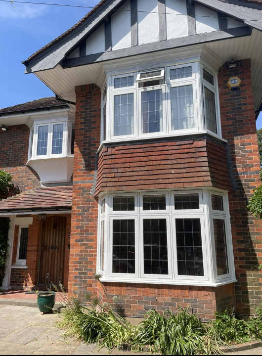 Replacement white leaded casement and bay windows on a Tudor-style house