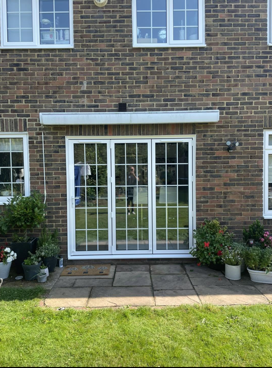 White bifold doors opening onto a rear garden