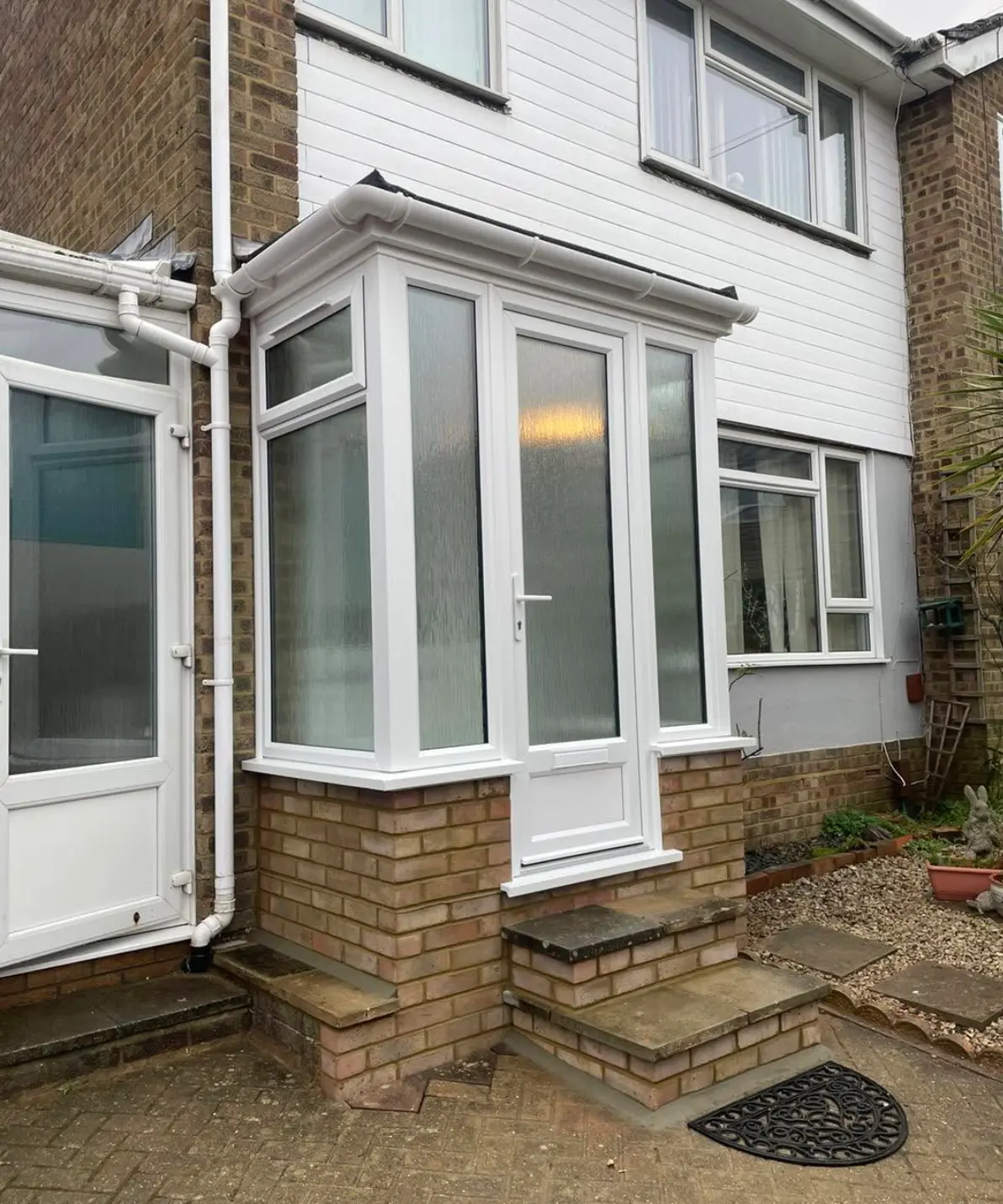 New white uPVC porch with a brick base and obscure glazing